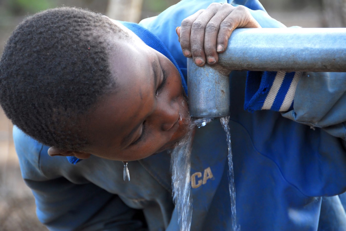 Illustrative image: A child drinking clean water from a borehole tap