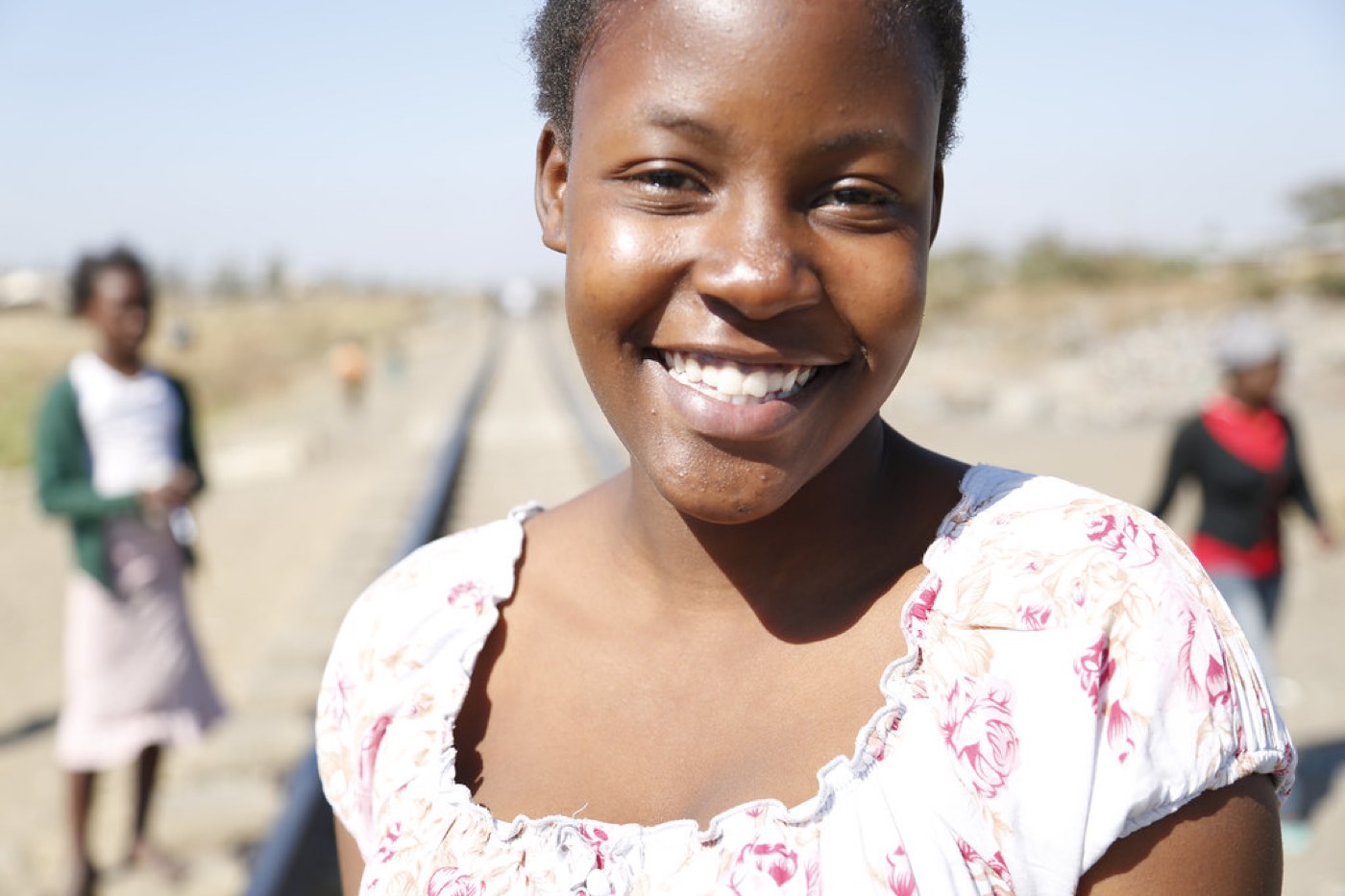 Illustrative image: A young woman smiling at a community programme